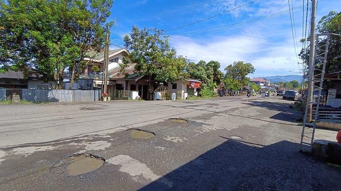 LUBANG - Kondisi jalan penghubung Upai-Bilalang di Kotamobagu, Sulut yang bertahun-tahun tak diperbaiki, Jumat 13 Juni 2025. Tampak banyak lubang di jalan tersebut.