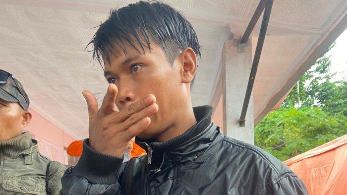 Nandar Sunandar memakai jaket dan baju milik almarhum ayahnya. Dia 5 hari melakukan pencarian dia di lokasi tanah longsor area pertambangan emas desa Tulabolo Timur Kecamatan Suwawa Timur Kabupaten Bone Bolango