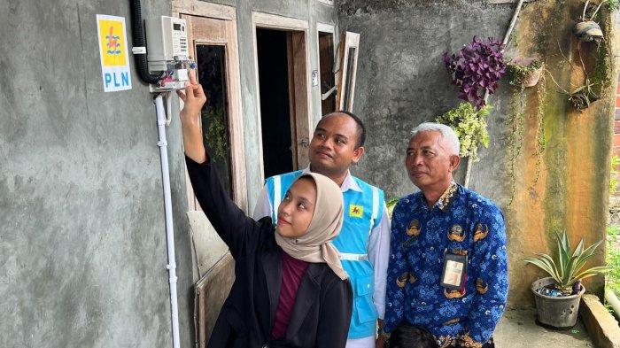 Penerima bantuan Program Light Up The Dream di Bantarsari, Kabupaten Cilacap, Jawa Tengah Putri Dwi Iwanti (kiri), menyalakan listrik rumahnya untuk pertama kalinya dampingi Manager PLN ULPSidareja, M. Yusuf Wibisana (tengah) dan Kepala Dusun Kamulyan, Sugiaji (kanan).