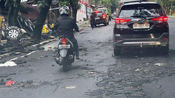 RUSAK - Jalan utama di depan SPN Karombasan Kota Manado Sulut, alami kerusakan pasca di terjang banjir bandang dari luapan air di drainase, Sabtu (1/3/2025).