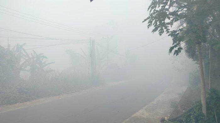 Ruas jalan di kelurahan Buha yang menghubungkan Kecamatan Mapanget dan Tuminting, Manado, Sulawesi Utara, dipenuhi asap dari kebakaran TPA Sumompo.