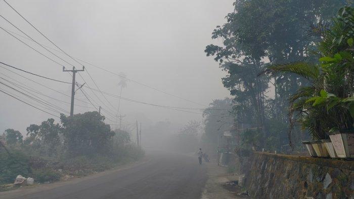 Ruas jalan di kelurahan Buha yang menghubungkan Kecamatan Mapanget dan Tuminting, Manado, Sulawesi Utara, dipenuhi asap dari kebakaran TPA Sumompo.