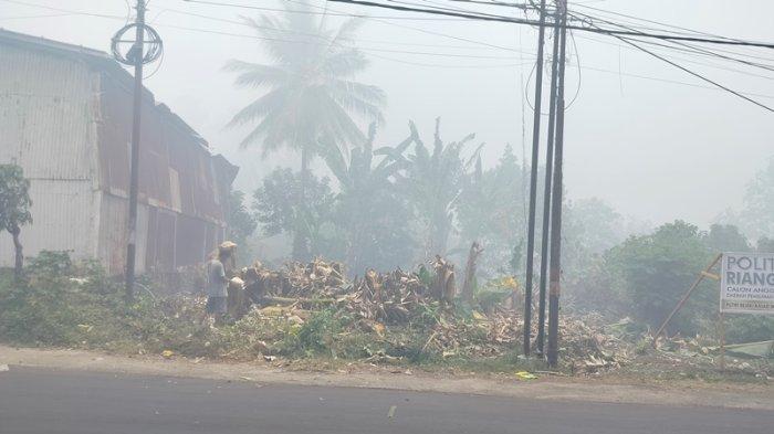 Ruas jalan di kelurahan Buha yang menghubungkan Kecamatan Mapanget dan Tuminting, Manado, Sulawesi Utara, dipenuhi asap dari kebakaran TPA Sumompo.