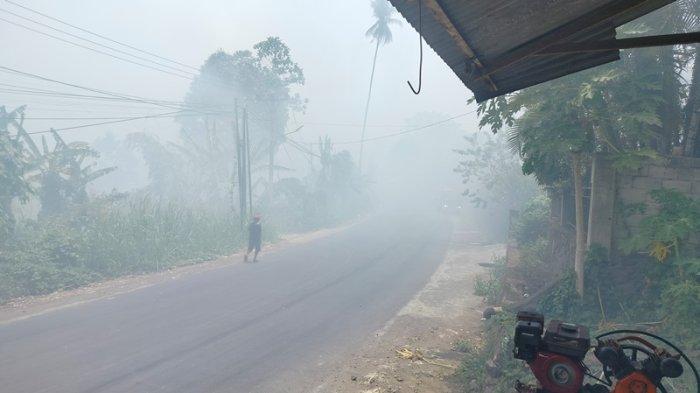 Ruas jalan di kelurahan Buha yang menghubungkan Kecamatan Mapanget dan Tuminting, Manado, Sulawesi Utara, dipenuhi asap dari kebakaran TPA Sumompo.