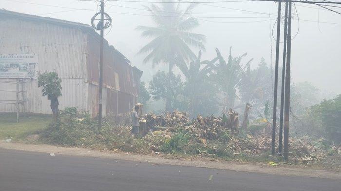 Ruas jalan di kelurahan Buha yang menghubungkan Kecamatan Mapanget dan Tuminting, Manado, Sulawesi Utara, dipenuhi asap dari kebakaran TPA Sumompo.