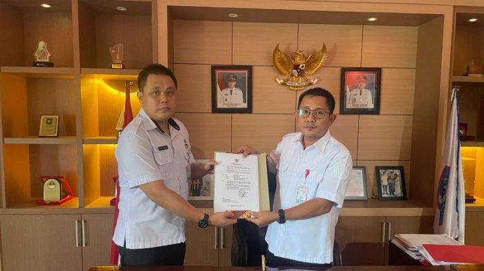PEMKOT BITUNG - Plt Kepala BKPSDMD Kota Bitung Richard Ticoalu Wowiling saat menerima SK dari Sekkot Bitung Rudy Theno. Wowiling bakal melaporkan ASN yang bolos selama tiga bulan ke Rudy Theno.