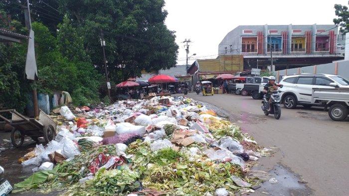 Tumpukan sampah penuhi setengah badan jalan di komplek Pasar 23 Maret Kotamobagu, Sabtu (14/12/2024).