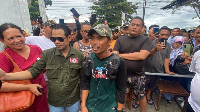 VIRAL - Potret Daeng Anpes, saat berada di Kolongan Beach Indah Hotel Malalayang Kota Manado, Sulawesi Utara, Selasa (11/2/2025). Ia menunjukan Sandal Kesembilan yang digunakan setelah perjalanan panjang.