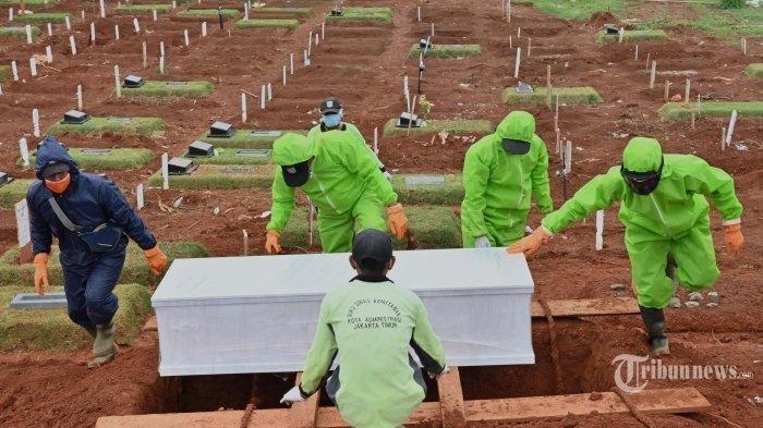 Sejumlah pekerja dari Dinas Pemakaman mengenakan alat pelindung diri (APD) saat menguburkan mayat di pemakaman yang ditunjuk untuk korban virus corona (Covid-19) di pemakaman Pondok Ranggon di Jakarta. Sabtu (2/5/2020).