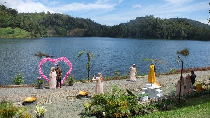 Sejumlah warga mengunjungi salah satu objek wisata di tepi Danau Moat yang berlokasi di Desa Moat, Kecamatan Modayag, Kabupaten Bolaang Mongondow, Minggu (11/7/2021).