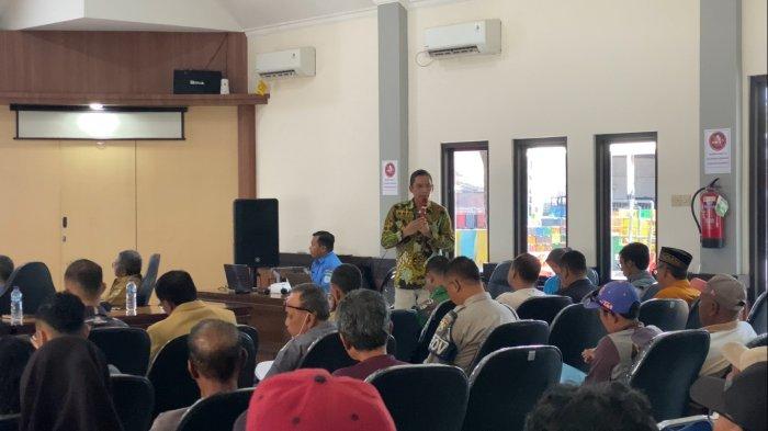 Edy Wiyono Tenaga Ahli Lingkungan Hidup berdiri memakai baju batik dan saat mengpresentasikan analisisi dampak lingkungan