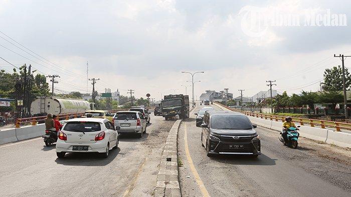 Sejumlah kendaraan melintas di Fly over Amplas Jalan Sisingamangaraja, Kota Medan, Senin (3/7) siang. Kecelakaan lalu lintas terjadi antara truk pengangkut batu koral pecah dan truk pengangkut batu bata, diduga sopir truk batu pecah BK 8906 BJ melarikan diri karena takut ditangkap polisi, usai truk yang dikemudikannya menabrak truk pengangkut batu bata BK 9357 MZ.