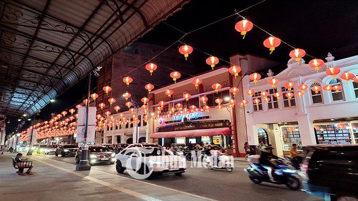 Sejumlah pengendara melintas di bawah hiasan lampion di Jalan Jenderal Ahmad Yani, Kesawan, Kecamatan Medan Barat, Kota Medan, Selasa (6/2). Kawasan Kesawan dihiasi dengan instalasi hiasan lampion untuk memeriahkan perayaan Hari Raya Imlek Tahun Naga 2575.