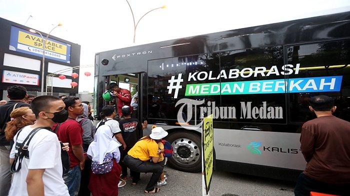 Warga mengantre masuk ke dalam bus listrik di Halte Plaza Medan Fair Jalan Gatot Subroto, Kota Medan, Selasa (9/1). Wali Kota Medan Bobby Nasution meresmikan empat mobil listrik, sumbangan dari perusahaan swasta PT Kalista Soter Hastia.