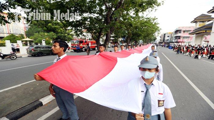 Puluhan pelajar SMA sedang berjalan sambil membawa bendera merah putih sepanjang 150 meter di Kota Medan, Selasa (13/9/2022) sore. Kirab Merah Putih mengangkat tema Menjaga Keharmonisan Menjunjung Tinggi Toleransi itu diikuti oleh anggota TNI, Polri, Pelajar, Pemuka Agama, Ormas, dan Masyarakat Umum dengan rute dari Istana Maimun menuju Taman Makam Pahlawan Bukit Barisan.