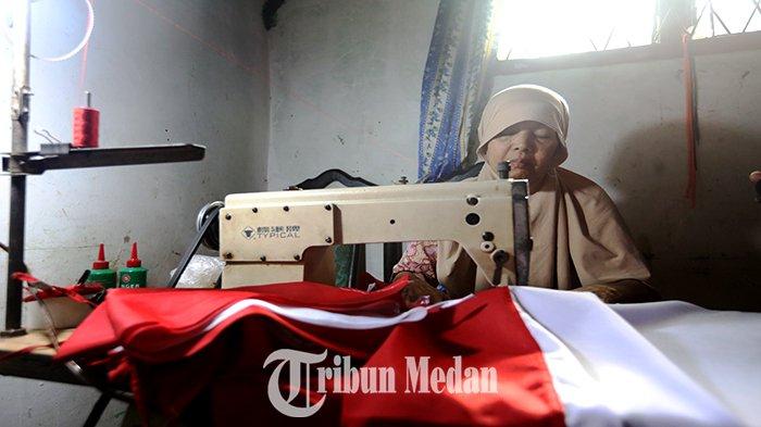Perajin musiman menjahit bendera merah putih di Jalan Bromo, Kota Medan, Senin (14/8). Perajin bendera musiman Sapnida (58) mengatakan, mampu memproduksi sebanyak 150 bendera dengan omzet mencapai Rp 2-3 juta per hari dengan harga jual Rp 125-300 ribu tergantung ukurannya.