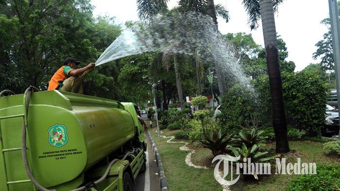 Petugas melakukan penyiraman tanaman di sepanjang median Jalan Sudirman, Medan, Senin (16/3/2020). Penyiraman tanaman tersebut untuk menghindari tanaman mengering selama musim kemarau.