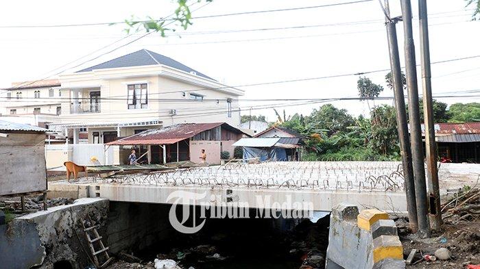 Warga melihat kondisi terkini proyek revitalisasi jembatan di Jalan Abdullah Lubis, Kecamatan Medan Baru, Kota Medan, Rabu (17/1). Pemko Medan melalui Dinas Sumber Daya Air Bina Marga Bina Konstruksi (SDABMBK) merevitalisasi jembatan Jalan Abdullah Lubis, menghabiskan biaya Rp 7,9 miliar dan ditargetkan selesai bulan Desember 2023 atau selama 100 hari masa kerja, namun sampai awal Januari 2024 belum selesai.