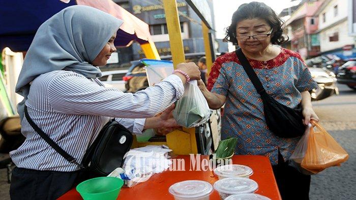 Pedagang takjil melayani pembeli di Jalan Taruma, Petisah Tengah, Kecamatan Medan Petisah, Kota Medan, Minggu (17/3/2024). Pada bulan suci Ramadhan 1445 Hijriah, para pedagang takjil musiman bermunculan dengan menawarkan aneka menu makanan dan minuman untuk berbuka puasa.