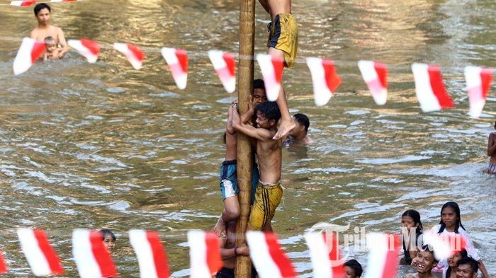 Sejumlah warga mengikuti lomba panjat pinang di Sungai Deli untuk mendapat hadiah dalam perayaan kemerdekaan ke-74 Republik Indonesia, di Medan, Sabtu (17/8/2019). Berbagai kegiatan diadakan di Sungai Deli tersebut, diantaranya upacara bendera, panjat pinang dan fashion show.