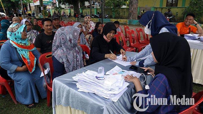 Petugas melayani penyaluran Bantuan Langsung Tunai (BLT) Bahan Bakar Minyak (BBM) kepada warga di Lapangan Sejati, Medan, Sabtu (17/9/2022). PT Pos Indonesia (Persero) menyalurkan dana BLT BBM dan Bantuan Program Sembako kepada 65.811 Keluarga Penerima Manfaat (KPM) di Kota Medan.