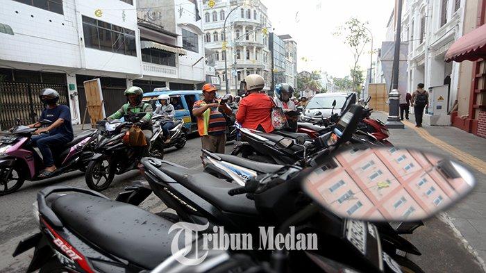 Petugas parkir elektronik (E-Parking) melayani warga yang membayar parkir melalui transaksi non tunai di Jalan Jenderal Ahmad Yani, Kesawan, Kecamatan Medan Barat, Kamis (18/4/2024). Pemko Medan dan DPRD Kota Medan menyepakati kenaikan tarif parkir, diatur dalam Perda Kota Medan Nomor 1 Tahun 2024 tentang Pajak Daerah dan Retribusi Daerah yang telah diundangkan pada tanggal 4 Januari 2024.