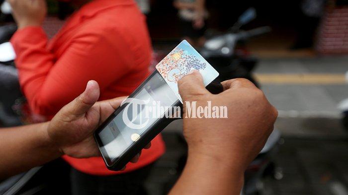 Petugas parkir elektronik (E-Parking) melayani warga yang membayar parkir melalui transaksi non tunai di Jalan Jenderal Ahmad Yani, Kesawan, Kecamatan Medan Barat, Kamis (18/4/2024). Pemko Medan dan DPRD Kota Medan menyepakati kenaikan tarif parkir, diatur dalam Perda Kota Medan Nomor 1 Tahun 2024 tentang Pajak Daerah dan Retribusi Daerah yang telah diundangkan pada tanggal 4 Januari 2024.