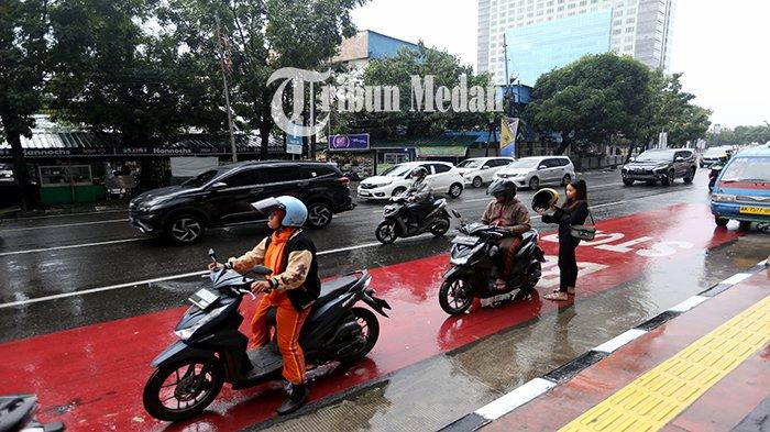 Sejumlah kendaraan melintas di Jalan Guru Patimpus, Kota Medan, Rabu (27/9). Balai Besar Meteorologi, Klimatologi, dan Geofisika (BMKG) Wilayah I Medan mengeluarkan peringatan dini waspada potensi hujan lebat yang dapat disertai petir dan angin kencang di wilayah Sumatera Utara.