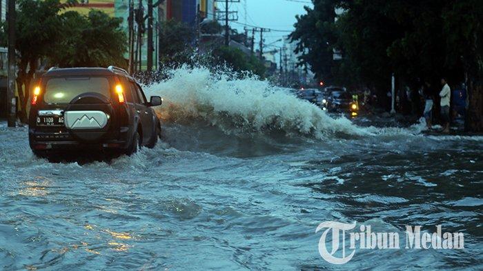 Pengendara mobil menerobos banjir di Jalan Sei Batang Hari, Medan, Jumat (29/9/2023). Hujan deras yang mengguyur Kota Medan menyebabkan sejumlah ruas jalan terendam banjir, dampak buruknya saluran drainase.