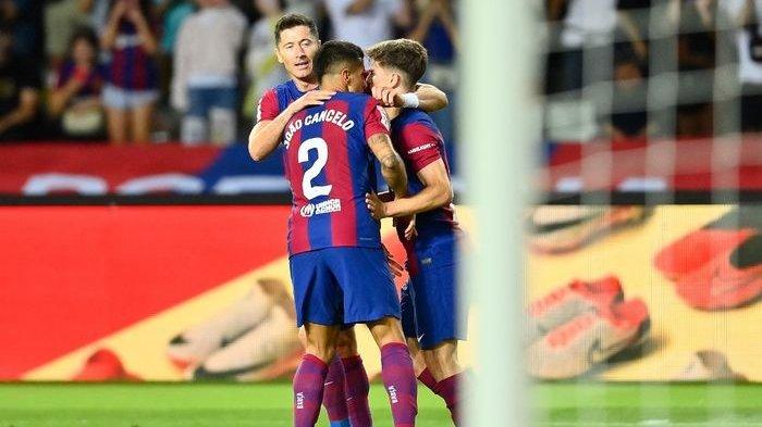Robert Lewandowski, Gavi, dan Joao Cancelo saling berpelukan setelah Barcelona menang dramatis atas Celta Vigo via comeback dengan skor 3-2.