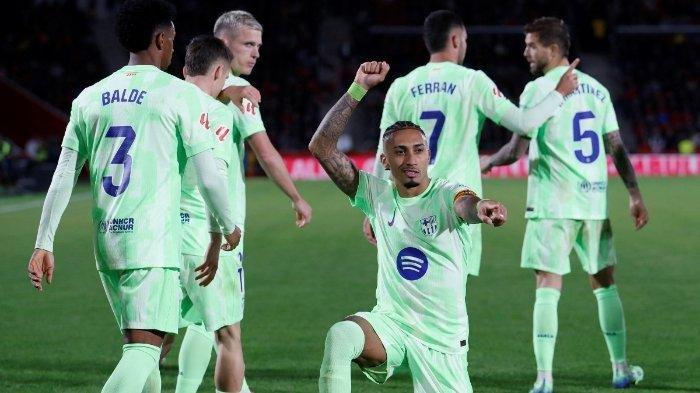 Penyerang Barcelona asal Brasil #11 Raphinha merayakan gol kedua timnya selama pertandingan sepak bola liga Spanyol antara RCD Mallorca dan FC Barcelona di stadion Mallorca Son Moix di Palma de Mallorca pada 3 Desember 2024. (JAIME REINA / AFP)