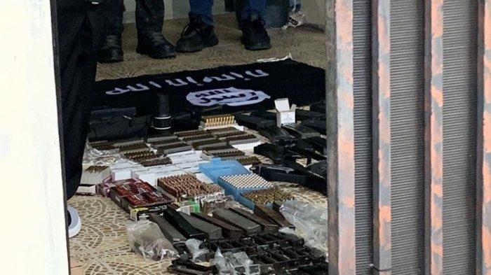 Tim Detasemen Khusus (Densus) 88 Antiteror Polri melakukan penggerebekan di rumah terduga teroris di Perumahan Pesona Anggrek Harapan, Bekasi Utara, Kota Bekasi, Senin (14/8/2023). Kediaman pemilik rumah sudah dibatasi garis polisi. Sejumlah anggota kepolisian berada di dalam rumah. Beberapa senjata api dan bendera yang terafiliasi ISIS dijejerkan di teras rumah terduga teroris berinisial DE tersebut.(KOMPAS.com/FIRDA JANATI)