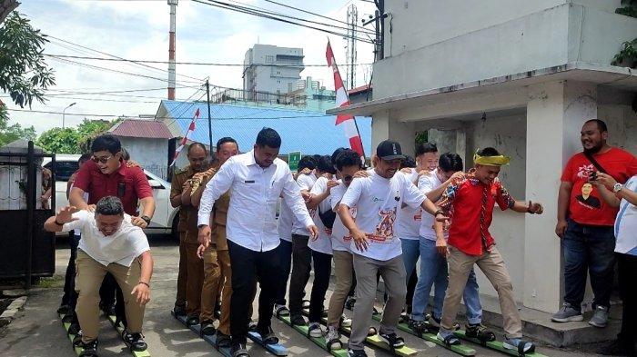 Wali Kota Bobby Nasution beserta timnya terjatuh saat ikuti permainan tradisional terompah, di Rumah Kolaborasi Jalan Cik Diktiro, Selasa (15/8/2023). \\