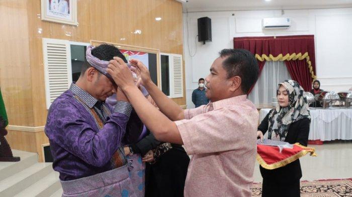 Bupati Sergai Darma Wijaya (kanan) memakaikan baju adat Sergai kepada Kajari Sergai yang baru, Mahyardi Indra Putra dalam agenda pisah sambut di Aula Pemkab, Senin (28/8/2023) malam.