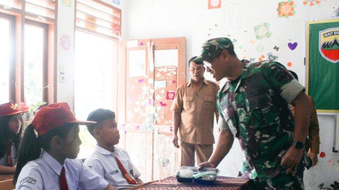 Dandim 0205/TK Letkol Inf Ahmad Rangkuti (kanan), membagikan program MBG kepada pelajar di tingkat SD, di kawasan Kecamatan Berastagi, Selasa (7/1/2025).