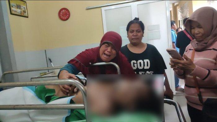 Dumaria Simangunsong memeluk jenazah suaminya di ruang jenazah Rumah Bhayangkara Medan, Kamis (16/12/2024). /Anugrah Nasution.