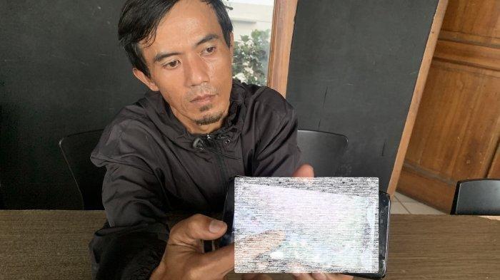 Ganjar Pamuji menunjukkan foto bekas operasi caesar istrinya yang mengeluarkan nanah setelah melahirkan di RSUD Cianjur. 