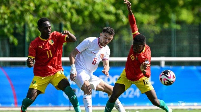 Gelandang Indonesia (6) Ivar Jenner (tengah) berebut bola dengan penyerang Guinea (11) Ousmane Camara (kiri) dan gelandang Guinea (18) Aguibou Camara (kanan) pada pertandingan play-off pra-Olimpiade antara Indonesia dan Guinea, untuk memperebutkan tempat terakhir dalam turnamen sepak bola Olimpiade putra Paris 2024, di Clairefontaine-en-Yvelines, selatan Paris, pada 9 Mei 2024. (MIGUEL MEDINA / AFP) (AFP/MIGUEL MEDINA)