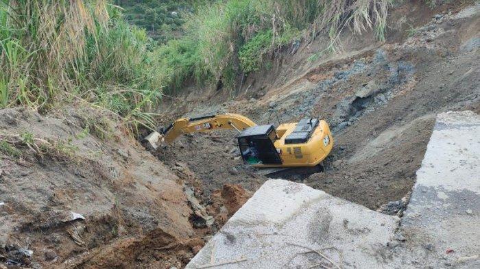 Jatuhnya alat berat excavator saat menimbun jalan yang amblas di Kecamatan Parbuluan Kabupaten Dairi, Jumat (11/10/2024).