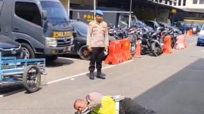 Jepretan layar Aiptu Rudi Hartono, personel Satlantas Polrestabes Medan yang viral melakukan pungutan liar (Pungli) ke pengendara sepeda motor dihukum guling-guling ke aspal dibawah terik matahari, Kamis (26/6/2025). Setelah dihukum guling-guling, ia dikurung dalam penempatan khusus (Patsus) Polrestabes Medan.
