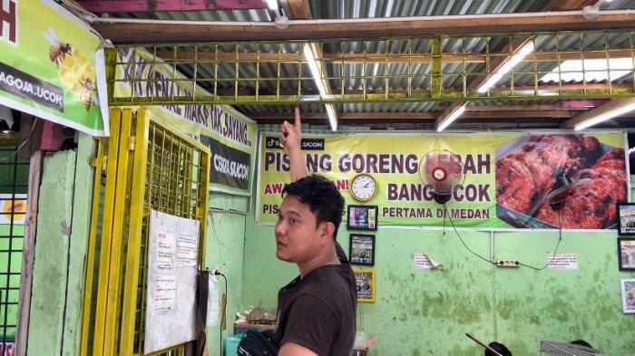  Jespin Fentha, menunjukkan engsel pintu warungnya yang sempat dibobol maling, Selasa (9/7/2024).