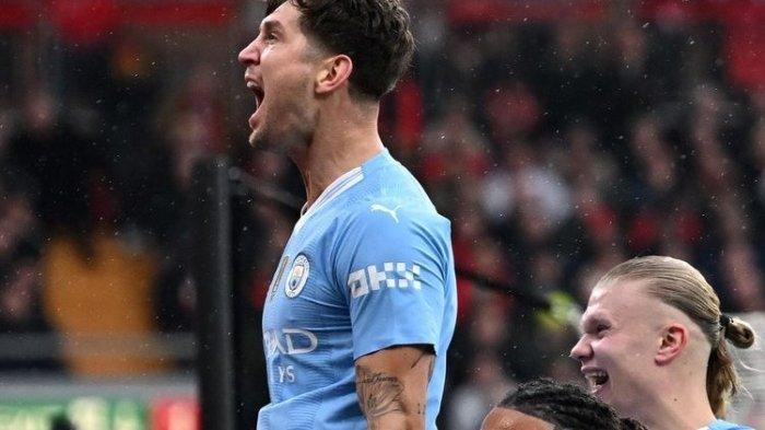 Pemain Man City, John Stones, merayakan gol pertama pada laga Liverpool vs Man City di ajang lanjutan Liga Inggris di Stadion Anfield, Minggu (10/3/2024).(AFP/PAUL ELLIS)