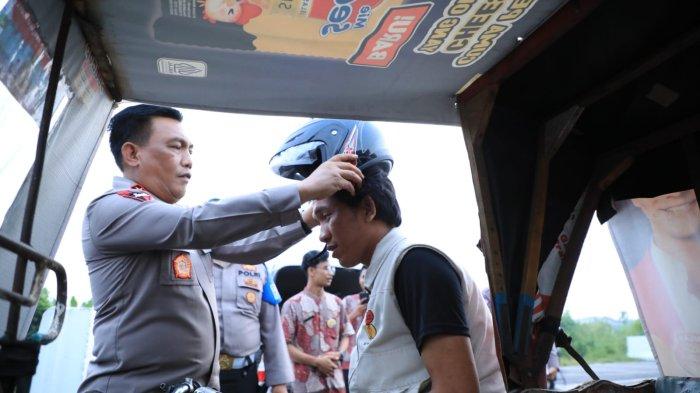 Kapolda Sumut Irjen Pol Panca Putra Simanjuntak memasangkan helem kepada Penarik Betor sebagai pelopor keselamatan sela-sela dengar Curhatan Pengendara Ojol dan Parbetor di Medan, Jumat (23/6/2023)