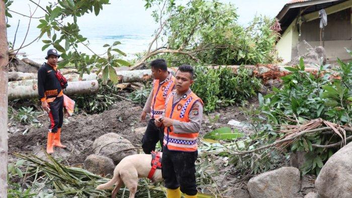 Personel Polda Sumut menmbawa anjin pelacak saat mencari 11 warga yang hilang akibat bencana alam tanah longsor yang terjadi di Dusun III, Desa Simangulampe, Kecamatan Bakti Raja, Kabupaten Humbang Hasundutan (Humbahas), Minggu (3/12/2023)