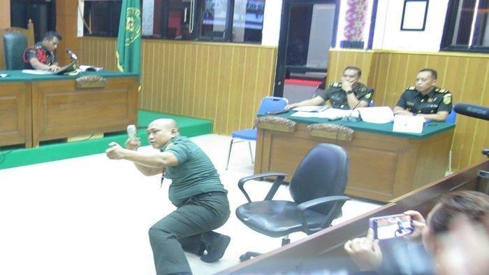 PERAGAKAN - Kopda Bazarsah memperagakan saat ia menembak tiga orang polisi Polres Way Kanan dan Polsek Negara Batin di persidangan Pengadilan Militer I-04 sebagai terdakwa, Senin (14/7/2025). Saat menembak korban terdakwa dengan posisi menjauh sambil mundur hingga setengah berdiri