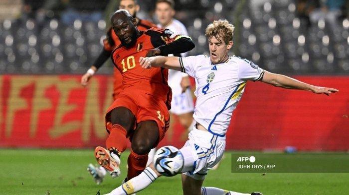 Penyerang Belgia Romelu Lukaku menendang bola di samping bek Swedia Filip Helander (kanan) selama pertandingan sepak bola kualifikasi Euro 2024 antara Belgia dan Swedia di Stadion King Baudouin di Brussels pada 16 Oktober 2023. JOHN THYS /AFP