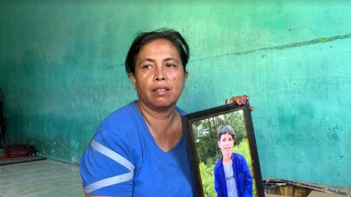 Lenny Damik, memegang foto anaknya yang tewas setelah diduga dianiaya oknum TNI AD dari Babinsa di bantaran rel kereta api Jalan Pelikan Ujung, Perumnas Mandala, Kecamatan Percut Sei Tuan, Deliserdang, Senin (27/5/2024).