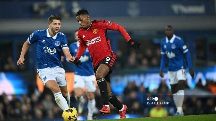 Striker Manchester United #09 Anthony Martial menembak dan mencetak gol ketiga timnya ke gawang tuan rumah Everton selama pertandingan sepak bola Liga Premier Inggris di Goodison Park, pada 26 November 2023. (Paul ELLIS / AFP)