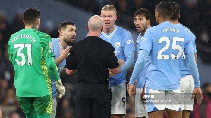 Para pemain Manchester City mengajukan banding kepada wasit Inggris Simon Hooper selama pertandingan sepak bola Liga Premier Inggris antara Manchester City dan Tottenham Hotspur di Stadion Etihad di Manchester, barat laut Inggris, pada 3 Desember 2023.