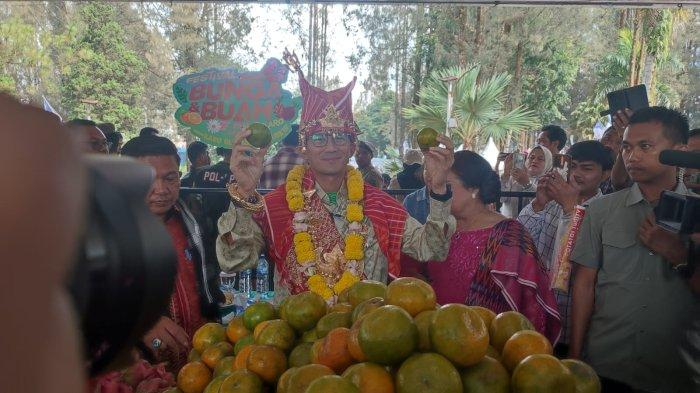 Menparekraf RI Sandiaga Salahuddin Uno mencicipi buah-buahan khas dari Kabupaten Karo, saat menghadiri Festival Bunga dan Buah Karo, di Taman Mejuah-Juah, Berastagi, Jumat (5/7/2024).